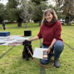 Dog training session with a smiling woman and her dog outdoors.