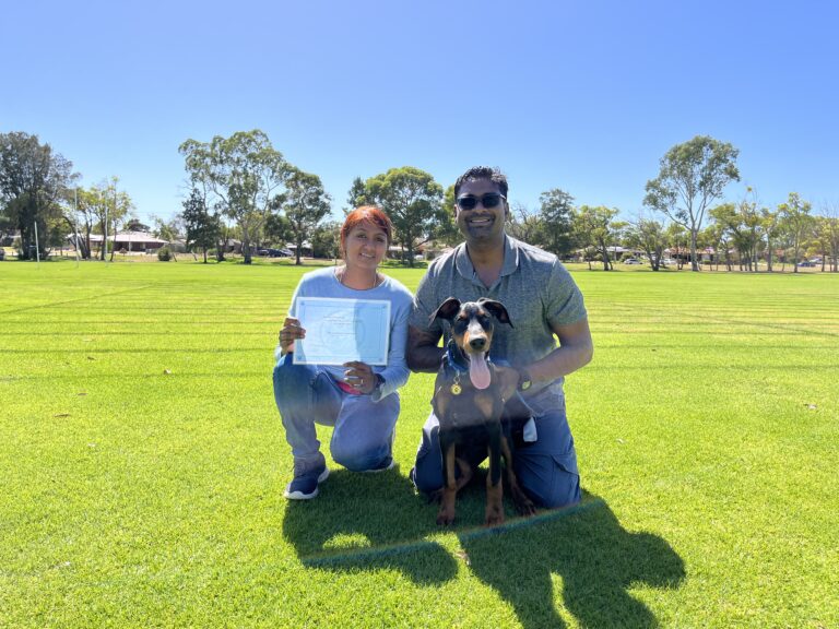 Happy dog and owners during agility training in a sunny park.