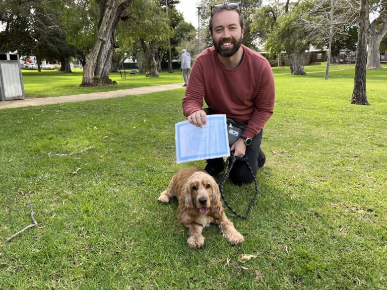Happy man with a dog during a training session in the park.