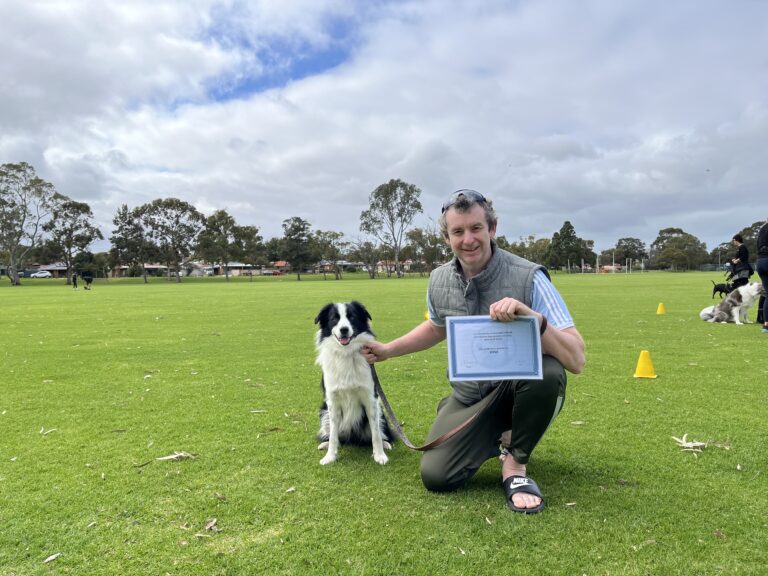 Agile Dogs dog training certification photo with a smiling trainer and a Border Collie in a park.