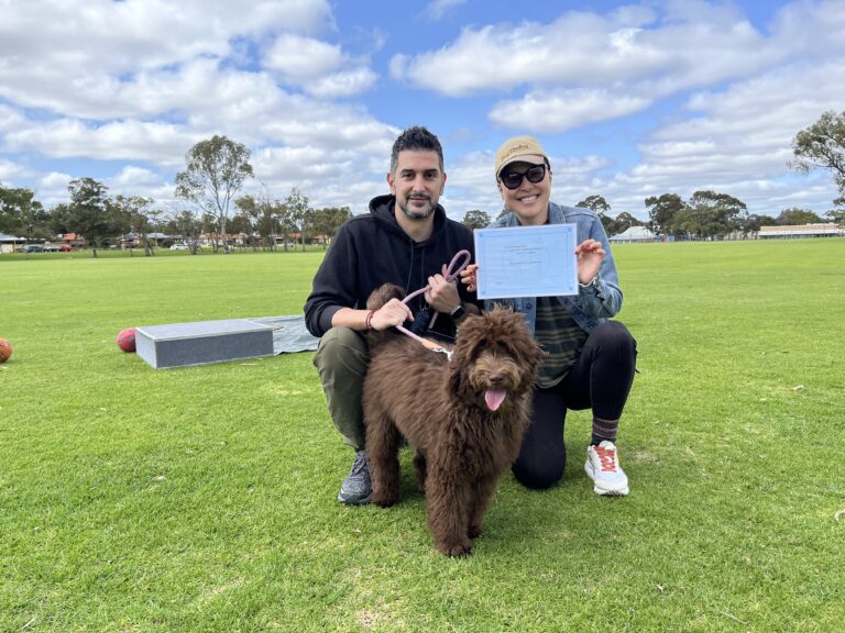 Happy dog owners with their certified dog at Agile Dogs training session.