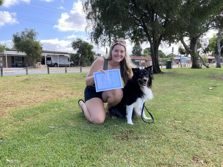 Woman with her dog celebrating dog training success outdoors.