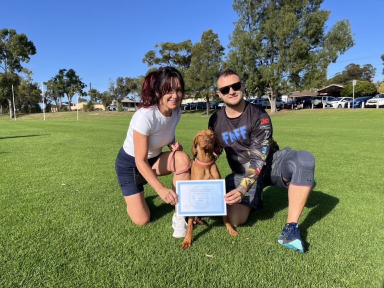 Happy dog owners with their certified dog at Agile Dogs training session.
